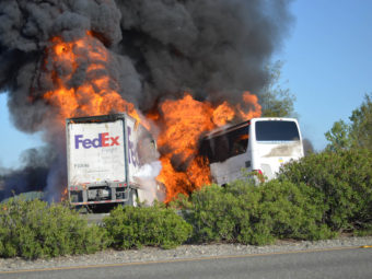 Flames devoured both vehicles just after a FedEx truck hit a charter bus Thursday in Northern California. At least 10 people were killed. The bus was carrying high school students who were going to visit a college. Jeremy Lockett/AP