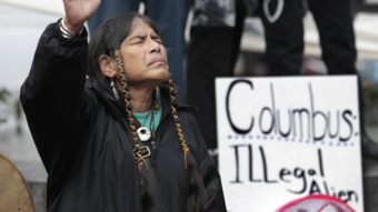 Columbus Day will be designated as Indigenous Peoples Day in Minneapolis, which has become one of several U.S. cities to make the change. Here, a member of the Cowichan Tribes holds her hand up in prayer during a 2011 Native American protest against Columbus Day in Seattle. Elaine Thompson/AP