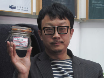 Beijing artist Liang Kegang poses in a Beijing art gallery earlier this week with the jar of fresh air he collected in Provence, France. Didi Tang/AP