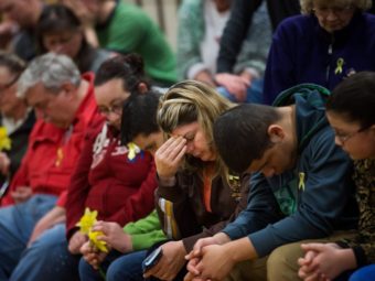 Residents bow their heads during a prayer service Friday at Haller Middle School in Arlington, Wash., that was dedicated to the communities affected by the Highway 530 mudslide. Marcus Yam/AP