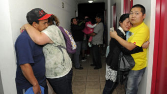 Scared residents hug in the hallway of an apartment building Tuesday after Iquique, Chile, was rocked by a strong earthquake. Cristian Viveros/AP