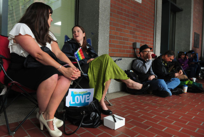 Julia Fraser (from left), Jessica Rohrbacher, Ken Brashier and Andrew Wallace await a ruling in the marriage equality case, so they can go into the building and get their marriage licenses. Steve Dykes /AP