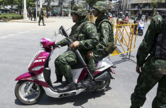 Thai soldiers patrol on a scooter Friday near the Democracy Monument in Bangkok. Thailand's ruling military summoned leaders of the ousted government to meetings today. Restrictions on TV broadcasts have led Thai citizens to ask for more variety. Apichart Weerawong/AP