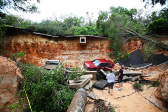 People survey the damage on Scenic Highway in Pensacola, Fla., after part of it collapsed following heavy rains and flash flooding on April 30. Marianna Massey/Getty Images