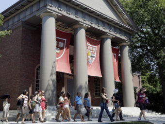 People tour the campus of Harvard University in Cambridge, Mass., in 2012. Harvard was one of 55 institutions on the Education Department's newly released list. Elise Amendola/AP