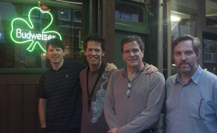 Four men stand outside an irish bar.