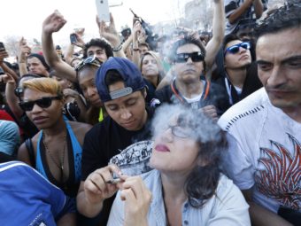Partygoers listen to live music and smoke pot on the second of two days at the annual 4/20 marijuana festival in Denver, last month. While the sale of marijuana is legal in the state, a legal finance mechanism is still in doubt. Brennan Linsley/AP