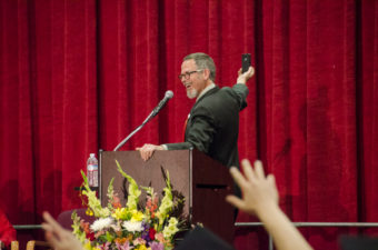 Retired teacher Clay Good kicked off his speech with a selfie from the stage. (Photo by Heather Bryant/KTOO)