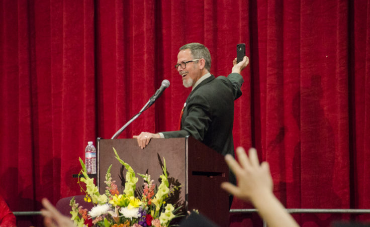 Retired teacher Clay Good kicked off his speech with a selfie from the stage. (Photo by Heather Bryant/KTOO)