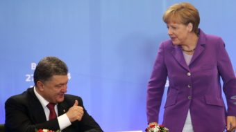 German Chancellor Angela Merkel speaks with Ukrainian President Petro Poroshenko, who signed a new economic deal with the EU at the organization's summit meetings Friday. Olivier Hoslet/AFP/Getty Images