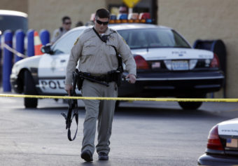 A Las Vegas police officer walks away from the scene of a shooting near a Wal-Mart on Sunday. John Locher/AP