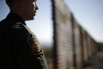 A Border Patrol agent looks to the north near where the border wall ends as it separates Tijuana, Mexico, (left) and San Diego. Gregory Bull/AP