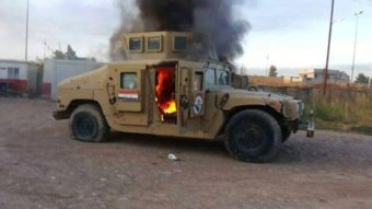 A cellphone photo shows an armored vehicle belonging to Iraqi security forces in flames Tuesday, after hundreds of militants launched a major assault in Mosul. Some 500,000 Iraqis have fled their homes in the large city since militants took control. AFP/Getty Images