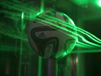 A close up of the Brazuca ball in NASA's Ames Fluid Mechanics Laboratory. Smoke highlighted by lasers visualizes air flow around the ball. NASA's Ames Research Center