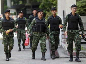 Thai soldiers walk after being deployed to guard Bangkok's Victory Monument against anti-army protests, on Sunday. The ruling junta is now insisting that foreign journalists not call the military takeover a coup. Wason Wanichakorn/AP
