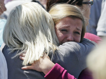 Freshman Hailee Siebert, 15, cries on her mother's shoulder after a shooting on Tuesday at Reynolds High School in Troutdale, Ore. The gunman has been identified as 15-year-old student Jared Michael Padgett. Rick Bowmer/AP