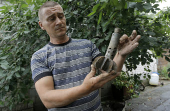 A man who lives in Ukraine's Donetsk region shows part of a shell that exploded in the yard of his house Wednesday, after a reported mortar attack by Ukrainian government forces Tuesday. The area is under a tense ceasefire that will expire Friday. Dmitry Lovetsky/AP