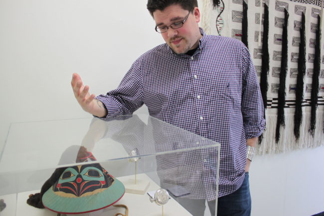 Juror David R. Boxley points out the beauty in Wayne Price's "Dancing Raven Hat," which Boxley awarded the competition's highest honor Best of Show. (Photo by Lisa Phu/KTOO)