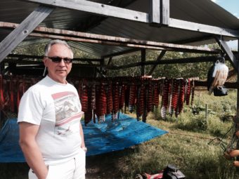 Arvin Dull, of Bethel, with his drying salmon at his fish camp in Oscarville Slough. (Photo by Daysha Eaton/KYUK)