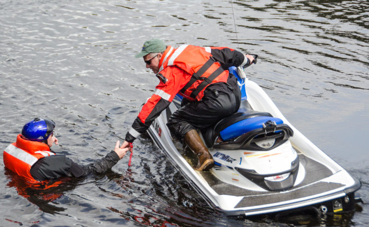 CBJ Park Ranger Dale Gosnell reaches for Mike Folkerts during a training exercise at Auke Lake (Photo by Heather Bryant/KTOO)