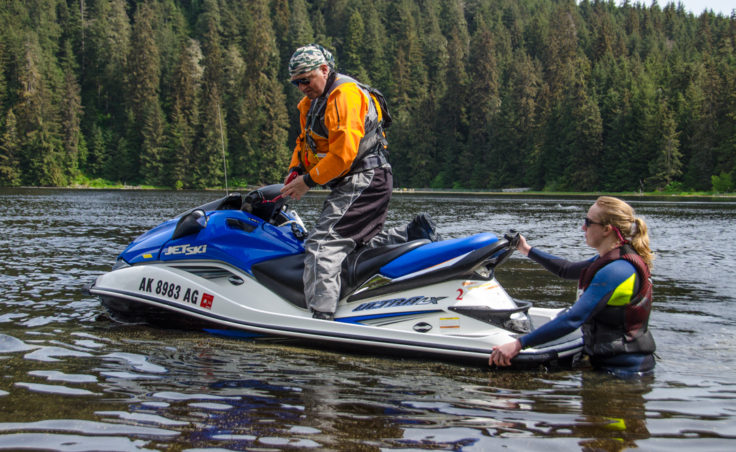 Stu Robards prepares to head out to the middle of the lake to practice fast turning as Lizzie Solger pushes him off. Solger is the president of the Juneau Personal Watercraft Club. (Photo by Heather Bryant/KTOO)