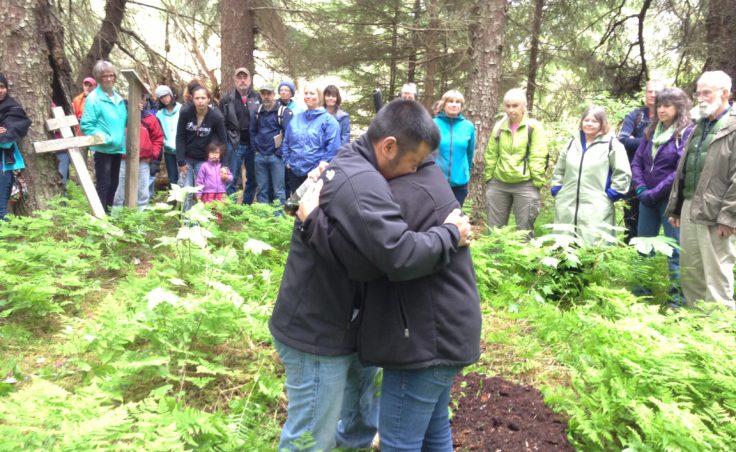 Martin Stepetin and wife Ann embrace when Martin breaks down in tears. Originally from St. Paul, Stepetin has family members who were interned in Funter Bay, 50 miles north of Killisnoo. (Photo by Lisa Phu/KTOO)