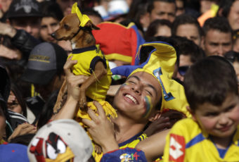 A Colombia soccer fan holds up his dog and celebrates a goal against Uruguay as he watches the World Cup round of 16 match on TV with others in Bogota, Colombia on Saturday. Javier Galeano/AP