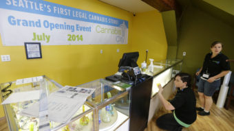 Amber McGowan, left, and Krystal Klacsan work Monday at Cannabis City in Seattle, a day before the store is to begin legal pot sales on Tuesday. The store will be for now the only one in Seattle to sell recreational marijuana. Ted S. Warren/AP