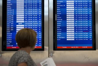 A woman passes by a departure board at Philadelphia International Airport showing that US Airways Flight 796 to Tel Aviv has been canceled Tuesday. Matt Rourke/AP