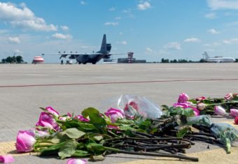 Flowers lay on the tarmac as a ground Hercules transport aircraft of the Royal Netherlands Air Force, carrying bodies from downed Malaysia Airlines Flight MH17, prepared to take off Wednesday in Kharkiv, Ukraine. Sergey Bobok /AFP/Getty Images
