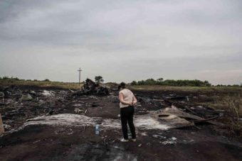 A woman looks at the wreckage of Malaysia Airlines Flight MH17 in Grabovka, Ukraine, on Friday. One day after the downing of the jetliner over eastern Ukraine, investigators are trying to learn more about the crash and who might be responsible. The passenger jet had nearly 300 people on board; none survived. Brendan Hoffman/Getty Images