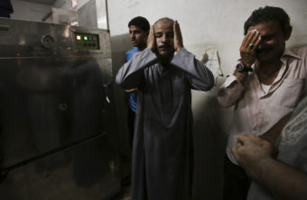 In the morgue of Gaza's Shifa hospital, Palestinian relatives mourn following an explosion that reportedly killed at least 10 people Monday, nine of them said to be children. Adel Hana/AP