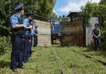 Police officers secure a refrigerated train loaded with bodies of the passengers of Malaysian Airlines flight MH17 as it arrives in a Kharkiv factory on Tuesday. Olga Ivashchenko/AP