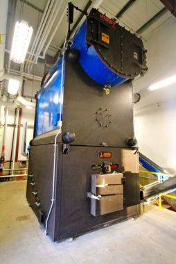 This biomass-fueled boiler at Tok School burns chipped timber waste to generate heat and electricity for the campus. ( KUAC file photo)