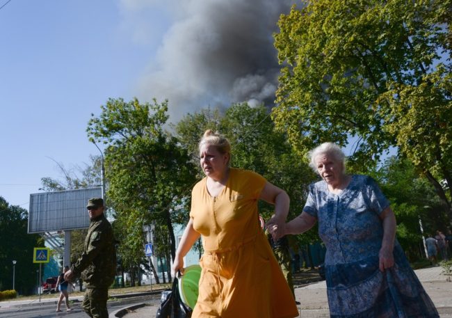 Women rush across the street after shelling in the town of Donetsk, Ukraine on Wednesday. Mstislav Chernov/AP