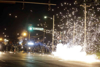 A device deployed by police goes off in the street as police and protesters clash Wednesday in Ferguson, Mo. Jeff Roberson/AP