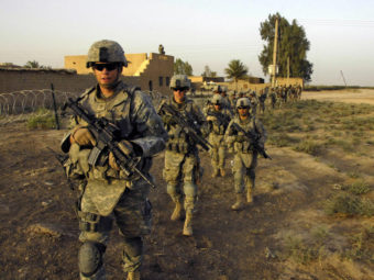 U.S. Army soldiers from 1st Platoon, G Troop, Task Force 1-35, 2nd Brigade Combat Team, move out on patrol in Iraq in 2008. A bipartisan panel says a Pentagon plan to cut Army strength go too far. Sgt. Eric C. Hein/AP
