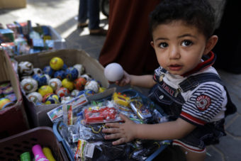 A Palestinian child goes through toys Wednesday at a vendor's stall in a market in Gaza City. Lefteris Pitarakis/AP