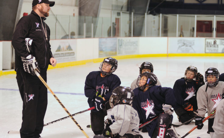 Rocky Mountain Hockey School coach Zac Desjardins gives instructions while Dylan Murdoch (center) and Joey Meir are fixed on the coach’s words during the first week of the new season at Treadwell Ice Arena.
