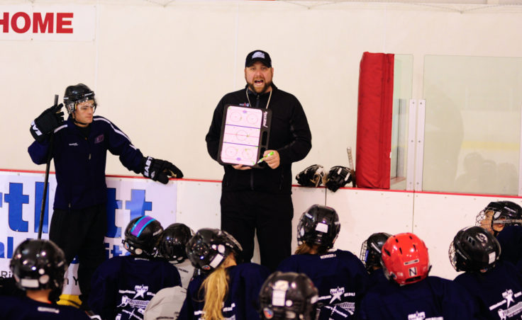 Rocky Mountain Hockey School coach Zac Desjardins draws up drill while players look on.