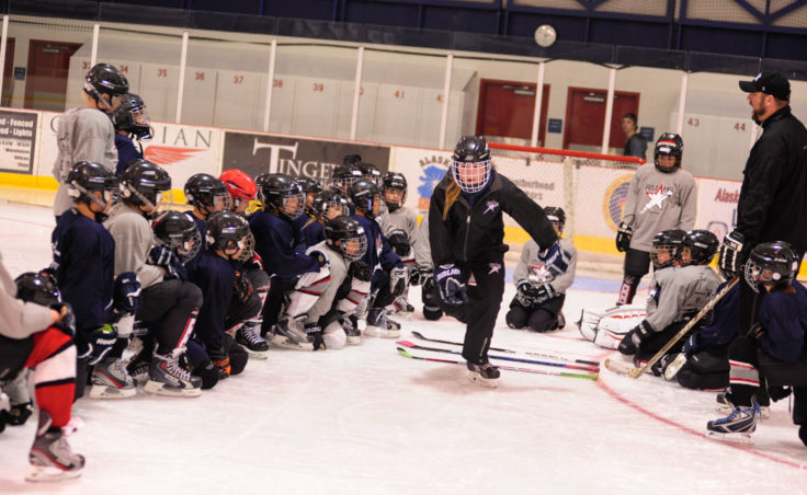 Emma Kaelke demonstrates a drill as young players look on during a Rocky Mountain Hockey School session at Treadwell Ice Arena.