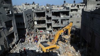Palestinian emergency personnel dig through the rubble of a building destroyed by an Israeli military strike in Rafah in the southern Gaza Strip on Thursday. Hamas announced that three of its senior military commanders were killed in a predawn Israeli airstrike. Said Khatib/AFP/Getty Images