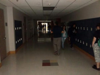 Students stand in a dark hallway at the Juneau-Douglas High School after the power went out this morning. (Photo by Mikko Wilson)