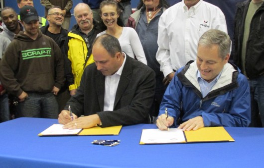 Adam Beck and Gov. Sean Parnell sign the contact for Vigor Alaska to build two new state ferries. (Photo from KRBD.org)