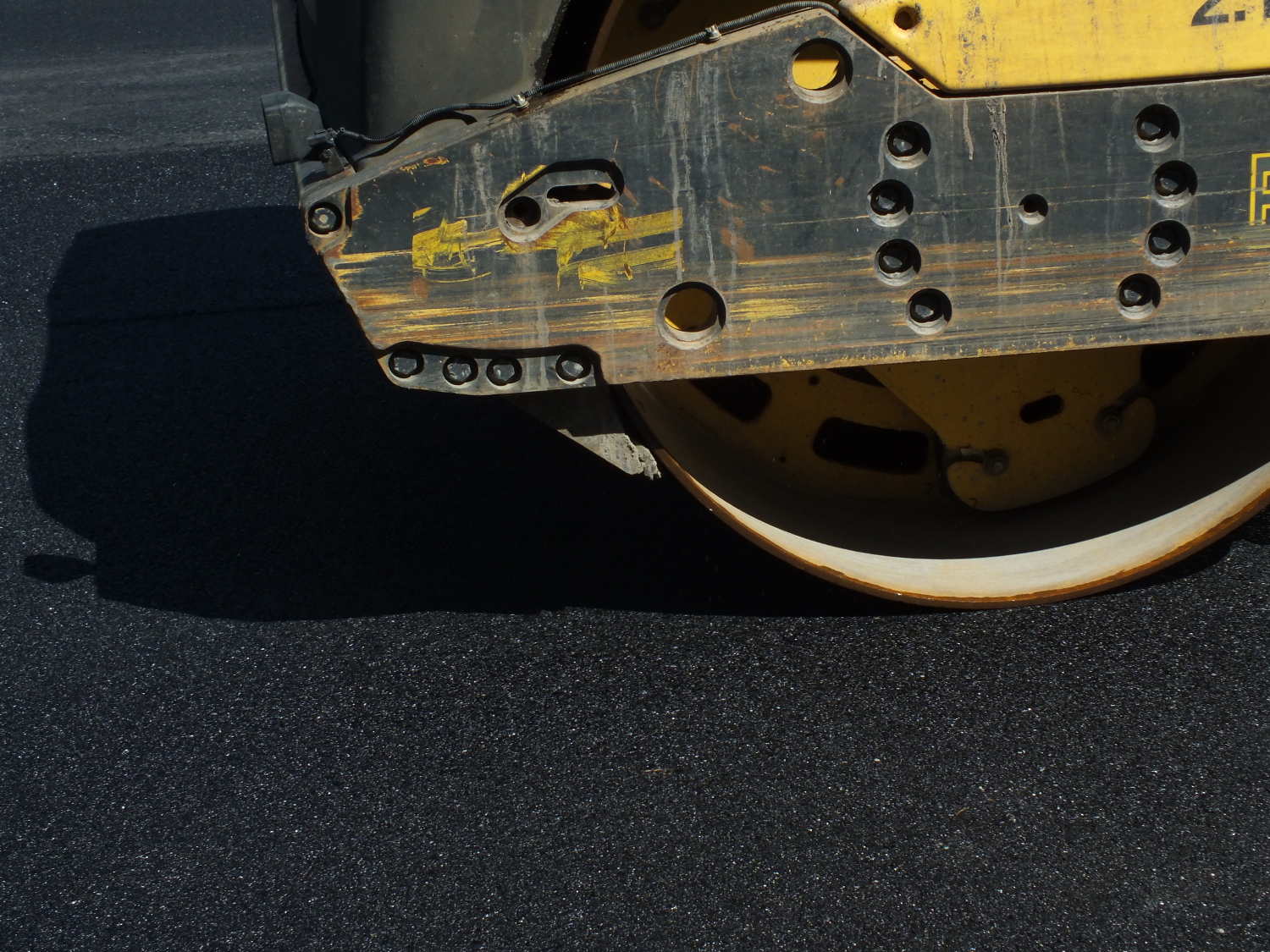 A roller makes a pass on the freshly laid asphalt mix to compress the aggregate. (Photo by Matt Miller/KTOO)