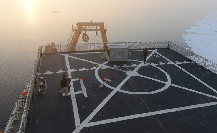 Chris Thompson and John Ferguson, Unmanned Aircraft System operators for AeroVironment, celebrate after successfully landing a Puma All Environment UAS onto the flight deck of the Coast Guard Cutter Healy during an exercise in the Arctic Aug. 18, 2014. The UAS' wings are designed to dislodge upon landing as a precaution against impact damage. (Coast Guard photo by Petty Officer 1st Class Shawn Eggert)