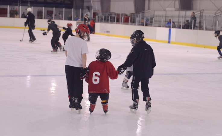 (From left) Gabe Miller and Karter Kolhase help Jed Davis enjoy an afternoon of skating and hockey during a Learn to Play afternoon sponsored by the Juneau Douglas Ice Association and Treadwell Ice Arena.