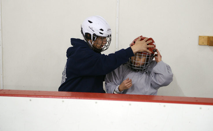 Cully Corrigan assists Emma Jessen with a helmet adjustment.