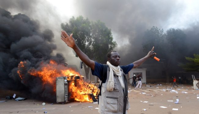 Demonstrators set fire to cars near Burkina Faso's Parliament on Thursday in Ouagadougou. Issouf Sanogo/AFP/Getty Images