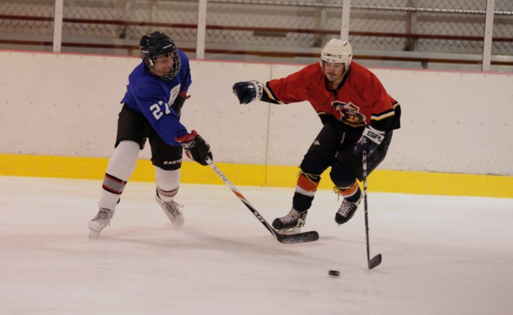 Viking’s Nolin Ainsworth (left) looks to clear a puck while Kensington’s Alex Gonneson gets his stick in front attempting to maintain team possession.